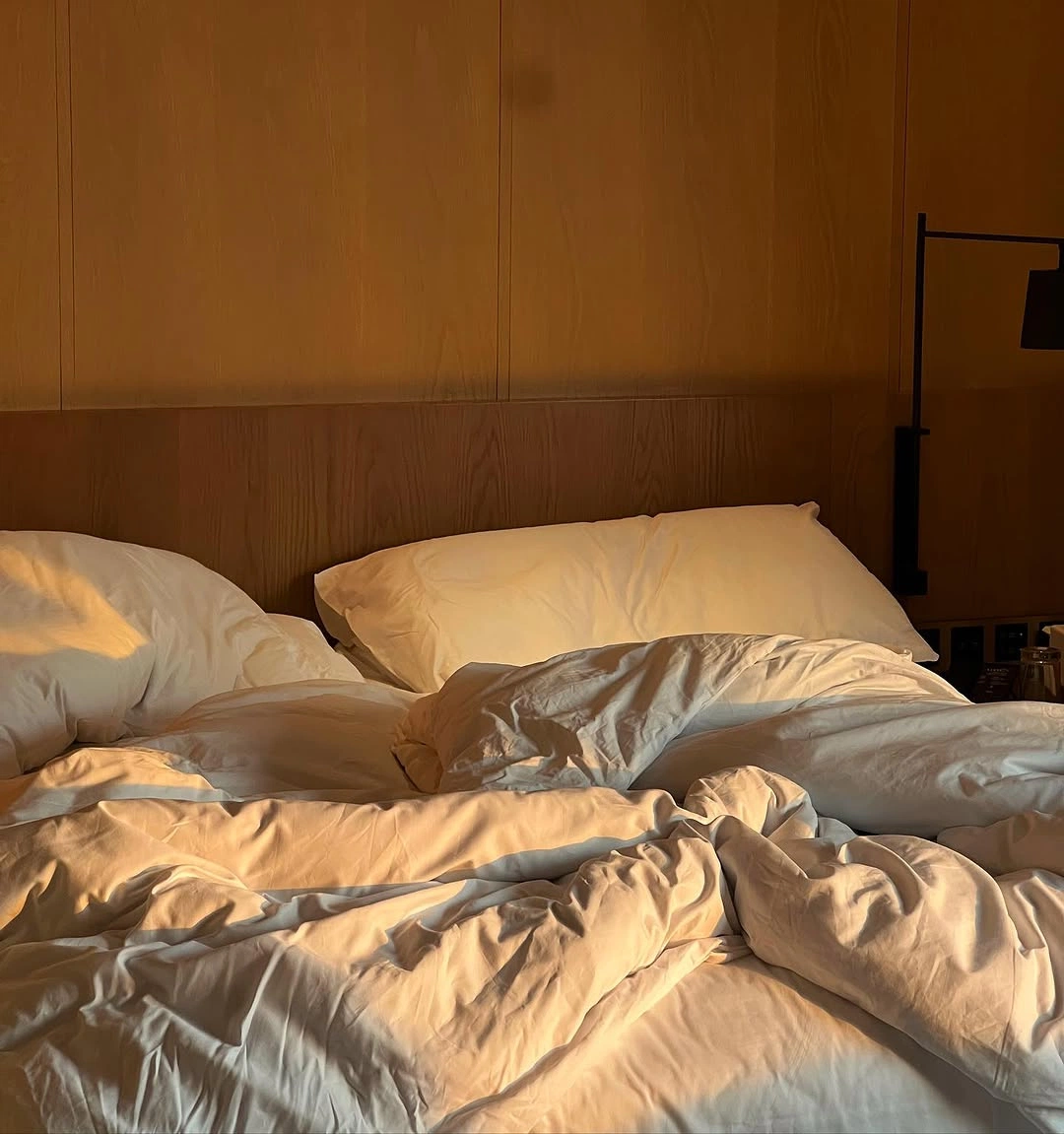 chambre avec un lit défait au réveil