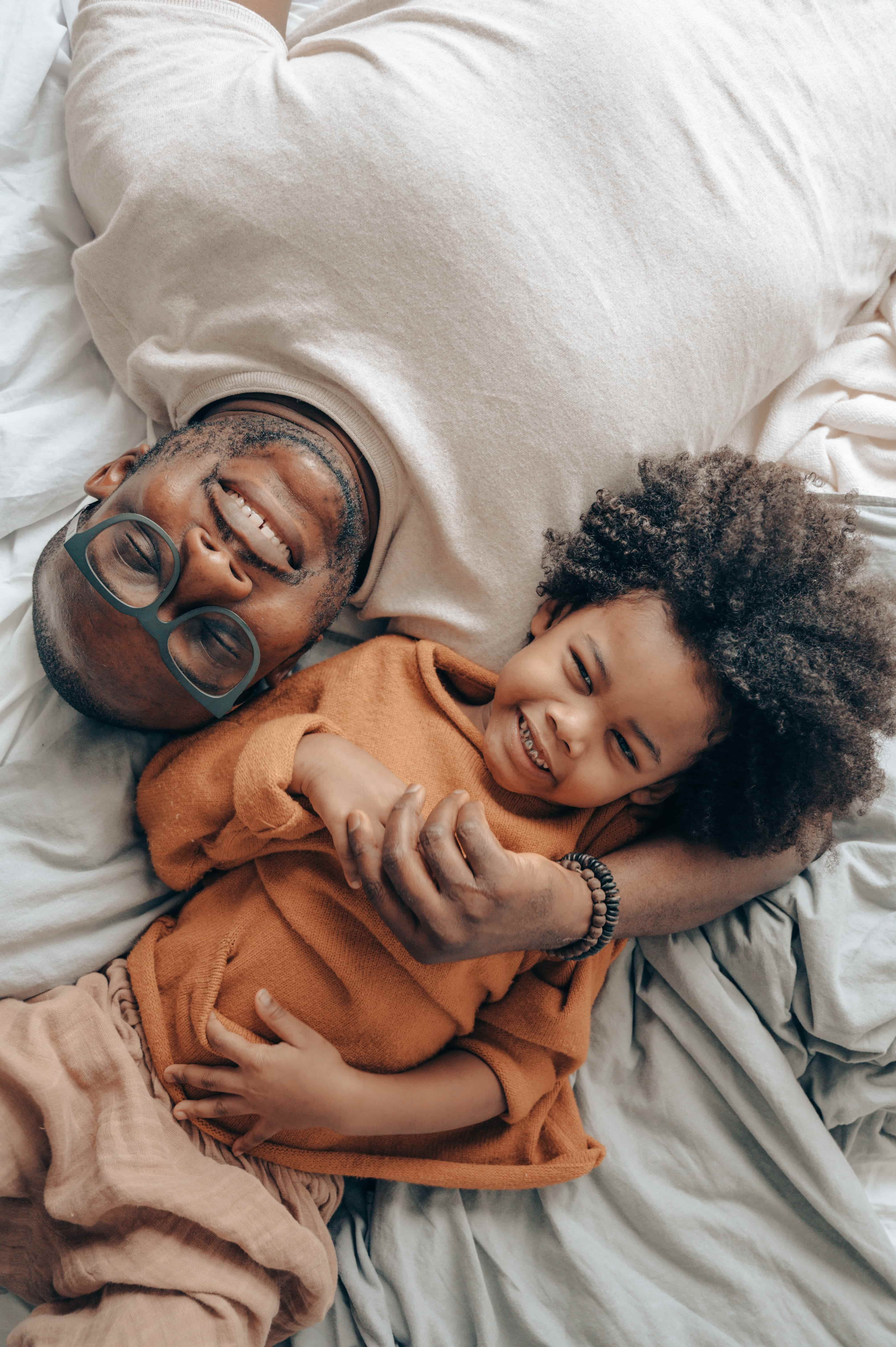 un papa et son enfant dans un lit