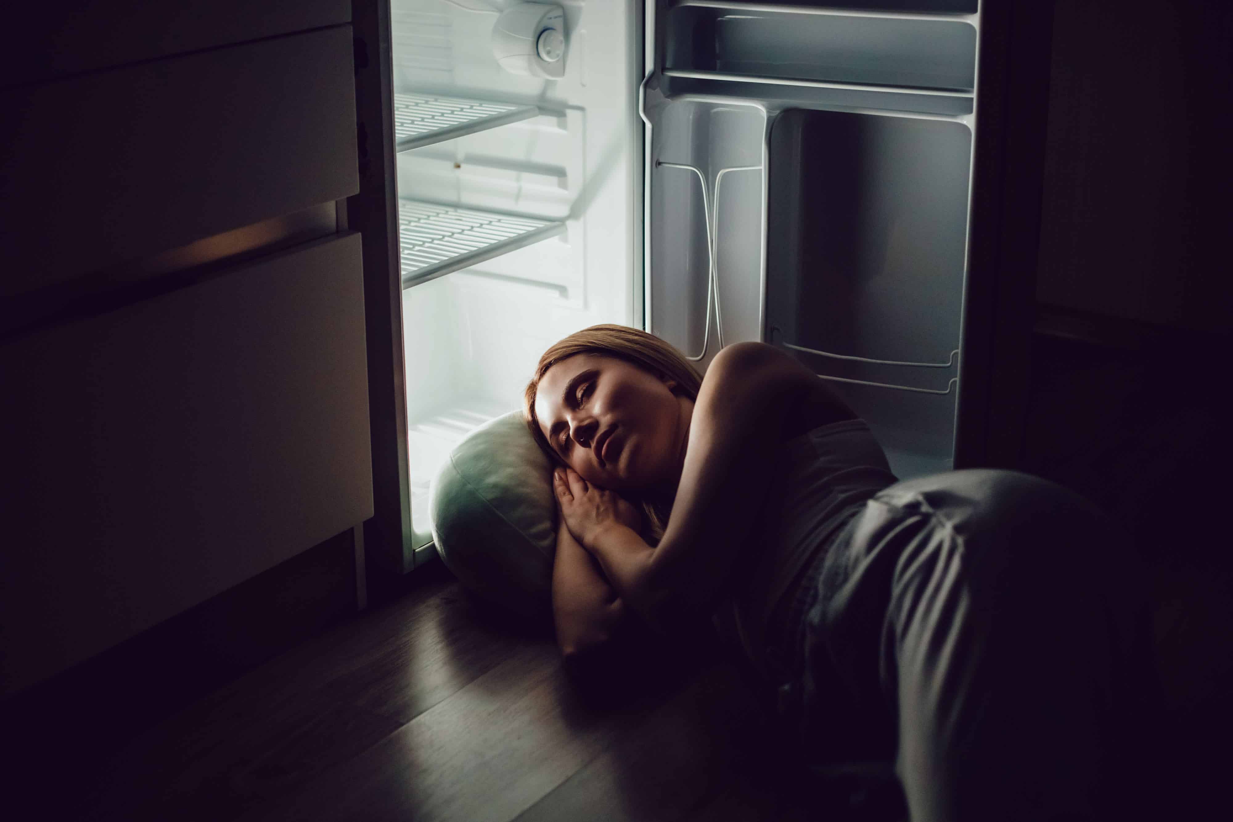 femme qui met dans tête dans le frigo